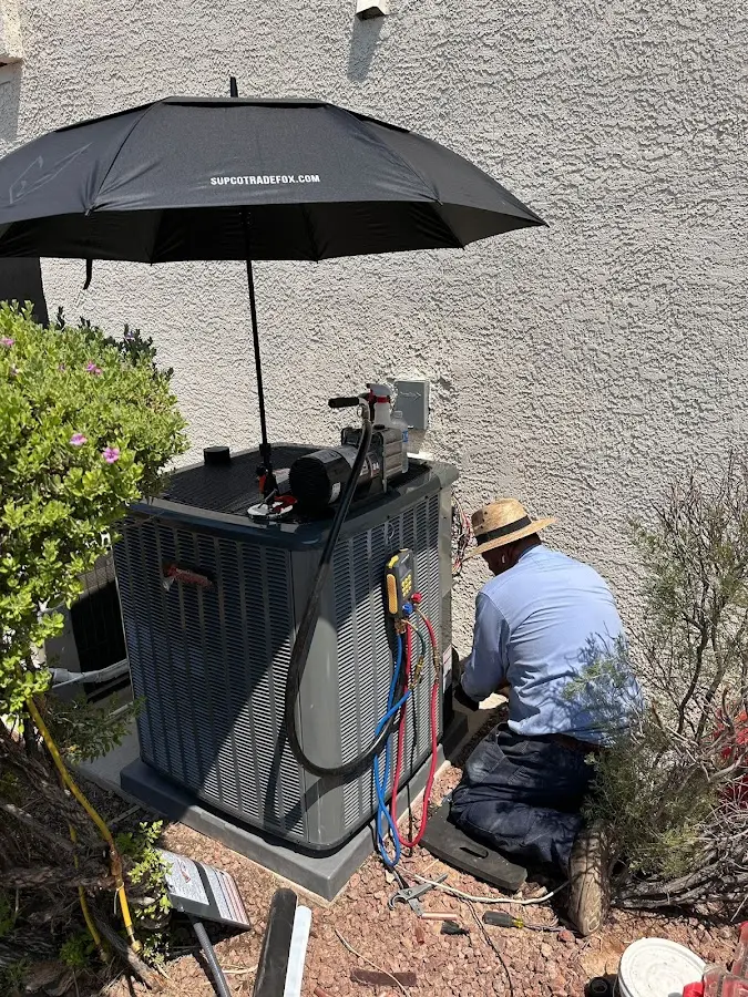 HVAC technician performing outdoor AC maintenance in Hermosa Beach