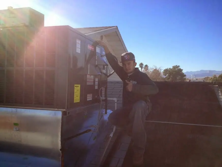 HVAC technician performing Air Duct Cleaning on a rooftop unit in Hermosa Beach